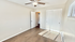Bright room with modern ceiling fan, wooden floors, and abundant natural light from a window with blinds.