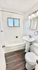 Bright, modern bathroom featuring elegant fixtures, a classic pedestal sink, and a soothing bathtub.