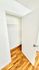 Bright, spacious closet with elegant hardwood flooring and clean white walls, offering ample storage space.