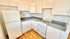 Bright and modern kitchen with sleek white cabinetry, classic gas stove, and rich hardwood flooring.