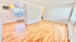 Bright, open living space with beautiful hardwood floors and large windows, perfect for modern living.