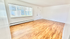 Bright and spacious living room with elegant wood flooring and large window offering abundant natural light.