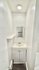 Compact and modern bathroom with sleek white vanity, large mirror, and minimalist design.