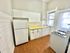 Bright and functional kitchen with modern appliances, ample white cabinetry, and classic tiled backsplash.