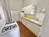 Charming kitchen with vintage gas stove, ample cabinetry, and bright white tiles.