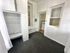 Charming small room with built-in shelving, bright white brick walls, and a window offering natural light.