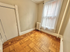 Charming room with elegant parquet flooring, large window with sheer curtains, and intricate wall detailing.