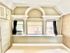 Beautiful room with classic arch details and built-in shelf space beneath a large window, offering ample natural light and charming architectural character.