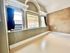 Bright room with elegant moldings, two large windows providing ample natural light, and a built-in air conditioner for comfort.