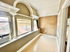 Charming sunlit room with vintage architectural details, featuring arched windows and elegant moldings, perfect for a cozy retreat.
