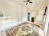 Charming room with a stylish ceiling fan, vintage radiator, and warm sunlight illuminating a beautiful patterned rug.