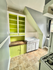 Charming kitchen with bright green accents, ample shelving, and a vintage sink area. Cozy and functional space.