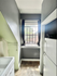 Charming kitchen nook with modern gray walls, large window with natural light, and sleek white appliances.