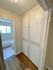 Charming hallway with elegant built-in storage leading to a bright bathroom.