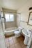 Bright and inviting bathroom featuring a bathtub, pedestal sink, and tiled floor with natural light.