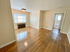 Bright and airy living space with polished hardwood floors, featuring large windows for ample natural light.