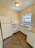 Charming kitchen with natural light, featuring white appliances, wood countertops, and ample cabinet space.