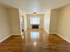 Bright, spacious living room with gleaming hardwood floors and abundant natural light, perfect for relaxation and entertaining.