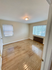 Bright, spacious bedroom with gleaming hardwood floors, large windows, and ample natural light.