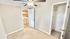 Cozy room with plush carpet, ceiling fan, and view into a modern laundry area with washer and dryer.