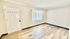 Bright, airy room with sleek hardwood floors, fresh white walls, and modern blinds; perfect for a cozy living space or home office.