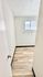Bright, minimalist hallway with sleek wood flooring and a frosted window, offering a modern touch.