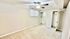 Bright bedroom with neutral colors, featuring a ceiling fan, plush carpet, and mirrored closet doors.