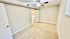 Bright and inviting empty room with plush carpet, ceiling fan, and open doorway leading to a laundry area.