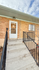 Inviting entrance to a charming brick apartment with a welcoming front porch and clean walkway.