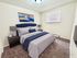 Inviting bedroom with plush carpet, elegant navy and white bedding, modern nightstands, and vibrant artwork.