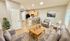 Inviting living area with modern decor featuring plush seating, a stylish coffee table, and an open-plan kitchen with breakfast bar and seating.
