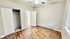Bright and airy bedroom with laminate flooring, closet space, and bathroom access in a modern apartment.