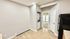 Bright and inviting apartment corner featuring modern wood flooring, in-unit laundry, and a glimpse into a sunlit room.