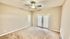 Bright and spacious bedroom with neutral carpet, ceiling fan, and French doors leading to a patio.