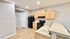 Modern kitchen with ample wooden cabinetry, sleek black appliances, and elegant tiled countertops.