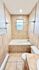 Modern bathroom featuring elegant tile design, a relaxing bathtub, and ambient lighting.