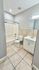 Modern bathroom featuring elegant tile flooring, a sleek vanity with ample storage, and a pristine shower-tub combination.