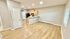 Inviting open-plan living and kitchen area with modern wooden flooring, ample natural light, and sleek cabinetry.