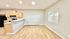 Inviting open-plan living and kitchen space with natural wood cabinetry and elegant flooring, enhancing the bright and airy ambiance.