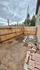 Cozy backyard space with a wooden privacy fence, ideal for gardening or outdoor relaxation, complemented by rustic brick details.