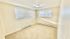 Bright and airy room with large windows, fresh white walls, and soft carpeting, perfect for a cozy bedroom or office space.