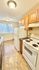 Bright kitchen with modern appliances, ample wooden cabinetry, and a large window offering a pleasant view, ideal for culinary creativity and comfort.
