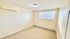 Bright, freshly painted room with large window offering natural light and cozy carpeting, perfect for a peaceful retreat.