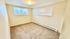 Bright and inviting room with large windows, neutral carpet, and soft lighting, perfect for personalizing.