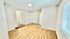 Bright and airy room featuring elegant wood flooring and modern white walls, perfect for a cozy and inviting living space.