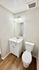Elegant bathroom with modern fixtures, featuring a sleek white vanity, stylish wall mirror, and contemporary lighting.