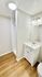 Sleek bathroom featuring modern white vanity, bright lighting, and wooden flooring for a stylish touch.