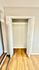 Bright, open closet with bi-fold doors, showcasing elegant wood flooring and a modern design.
