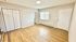 Bright room with wood flooring, modern closet doors, and large window for natural light.