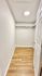Bright, spacious walk-in closet with wood flooring and ample shelving.